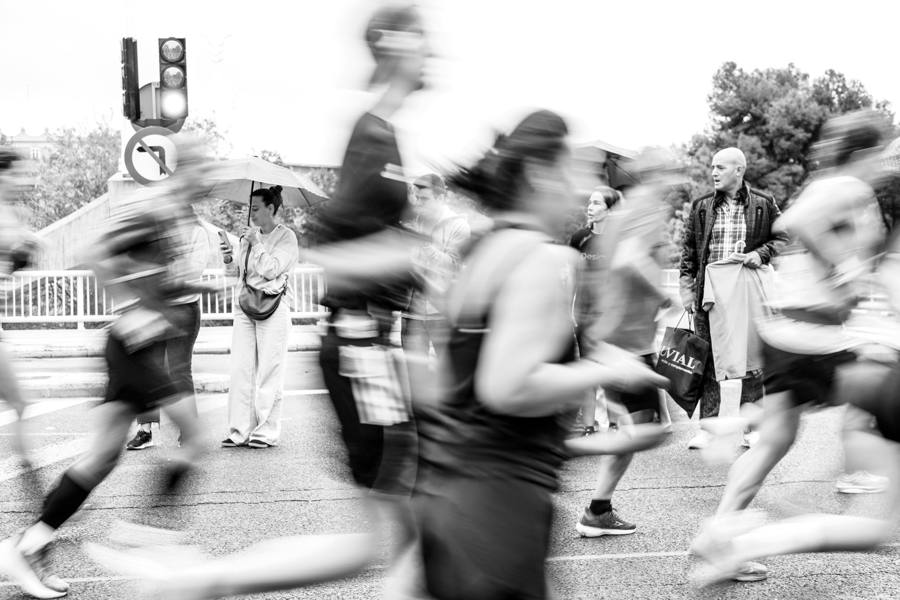 Black and white marathon runner blurred past a crowd