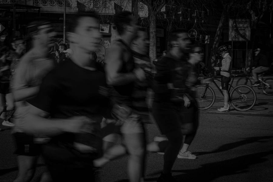 Runners moving through a dark street in motion blur